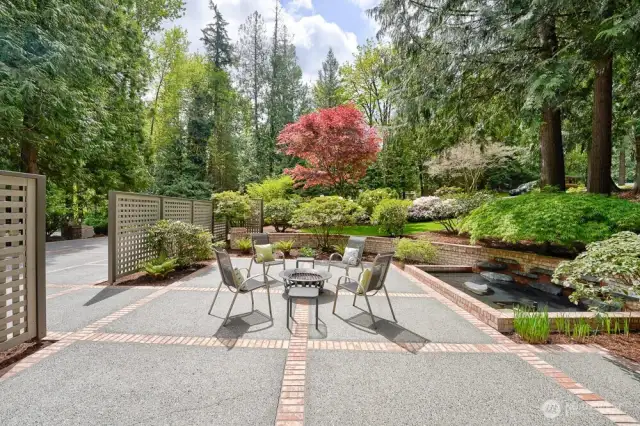 Private front concrete patio with brick inlays and circulating lighted water feature