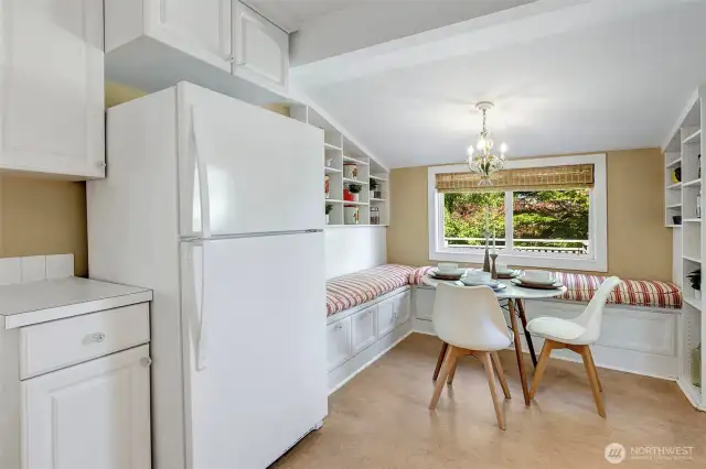Kitchen eating area with a large window overlooking the rear deck and yard.
