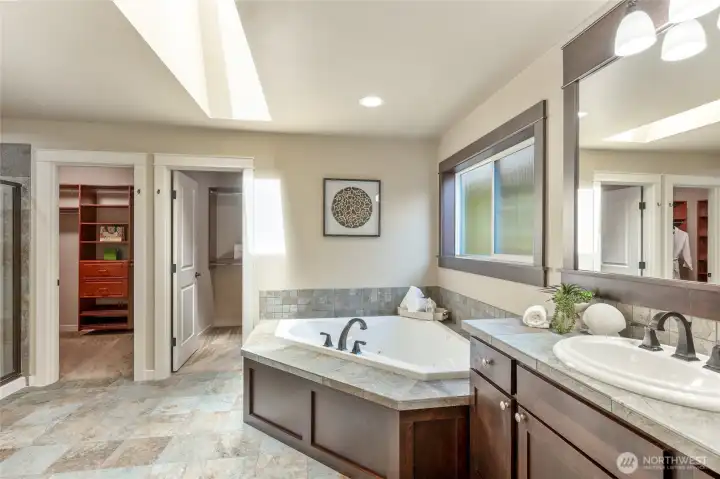Primary ensuite, with soaking tub, separate shower, and separate vanities.