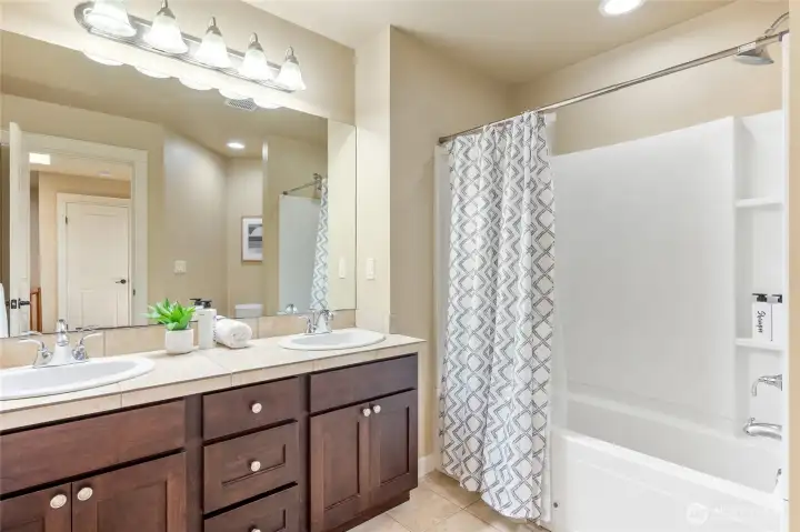Full-size upper level bathroom with dual sink vanity