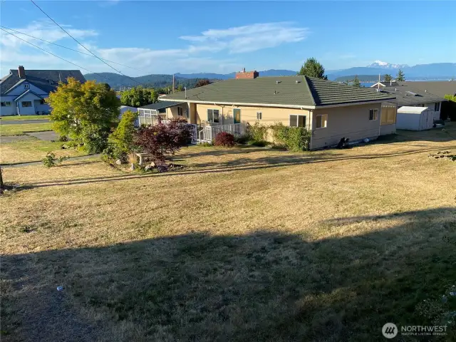 Looking northeast from near northern westerly corner prior to the alley easement that crosses left to right close to the line of shadow that goes near the house there that’s off this property.