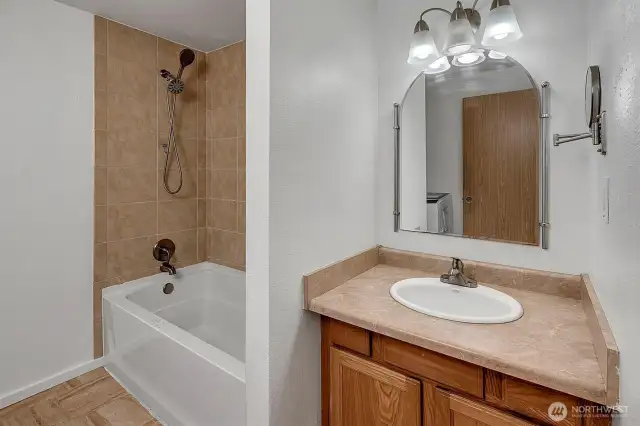 Full size tub with tile surround shower.