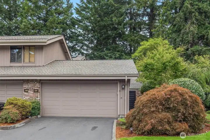 Nestled in natural surroundings, the home offers just one shared wall, driveway parking, and an attached 2-car garage with built-in shelving, a deep storage closet, and a utility sink with hose bib.