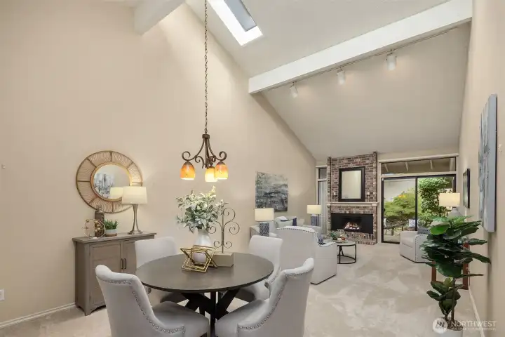 The dining and living rooms flow together, featuring vaulted ceilings with skylights and clerestory windows.