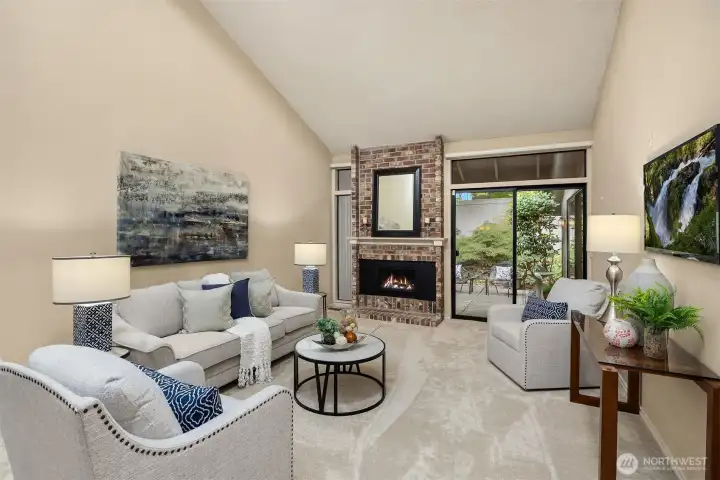 The living room showcases a gas fireplace and a glass slider with a transom window leading to the back patio.