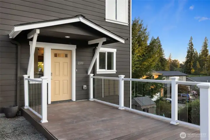 Welcome home to a thoughtfully designed entrance that blends style with low-maintenance living. The street-level entry opens to a spacious composite deck — perfect for greeting guests or enjoying a quiet moment outdoors — while clean architectural lines and modern railing details set the tone for the contemporary design found throughout the home.