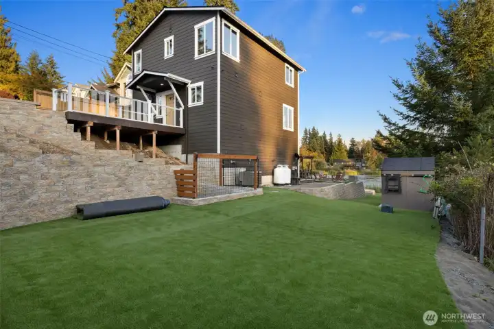 Expansive side yard designed with ease and functionality in mind. Professionally landscaped with high-quality artificial turf, this versatile outdoor space offers a lush, green look year-round — perfect for play, pets, or future garden plans. A gently sloped gravel ramp provides convenient access to the backyard and entertaining areas, blending practicality with thoughtful design.