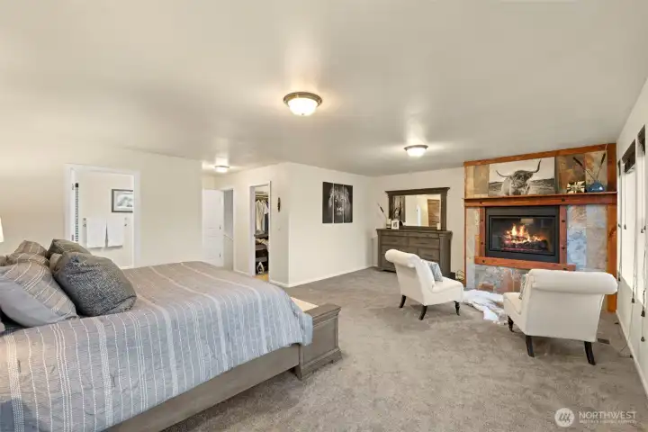 Designed with comfort and convenience in mind, the primary suite features thoughtful touches throughout — including a spacious walk-in closet and an en suite bathroom just steps from the bedroom. A propane-fueled fireplace anchors the sitting area, creating a cozy retreat within the room, while the generous layout offers plenty of space to relax and unwind.