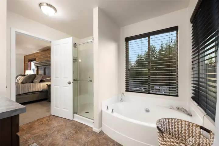 Unwind in the deep soaking tub framed by picture windows, or enjoy the convenience of a separate walk-in shower. This inviting ensuite blends everyday practicality with spa-like comfort, creating a peaceful retreat just steps from the primary suite.
