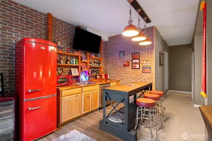 The retro-style refrigerator and shelving add character and charm while maintaining functionality. Combined with the long dining or prep island, this area makes hosting easy — whether it’s morning coffee, happy hour, or movie night snacks.