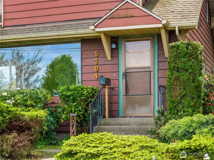 Welcoming front steps lead to a charming entryway, showcasing the timeless character and warmth of this 1927 North Tacoma home.