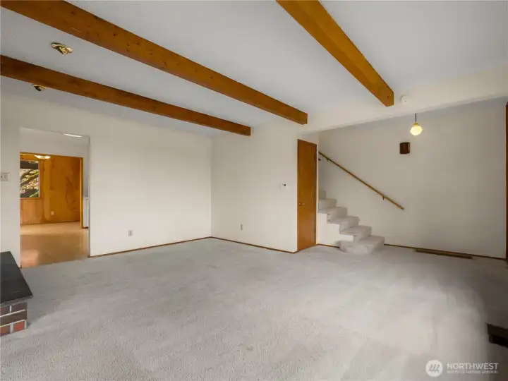 Spacious living area showcases beautiful wood beam accents, adding warmth, character, and timeless architectural charm.