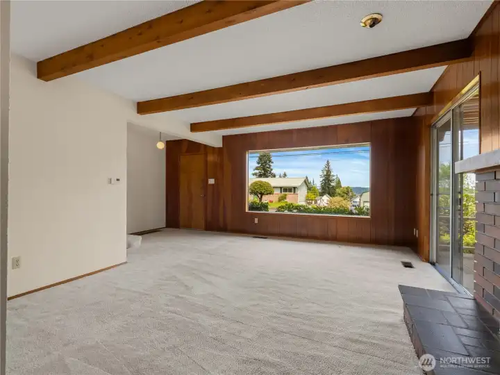 Living room features a large picture window that frames stunning views of Puget Sound while filling the space with natural light.