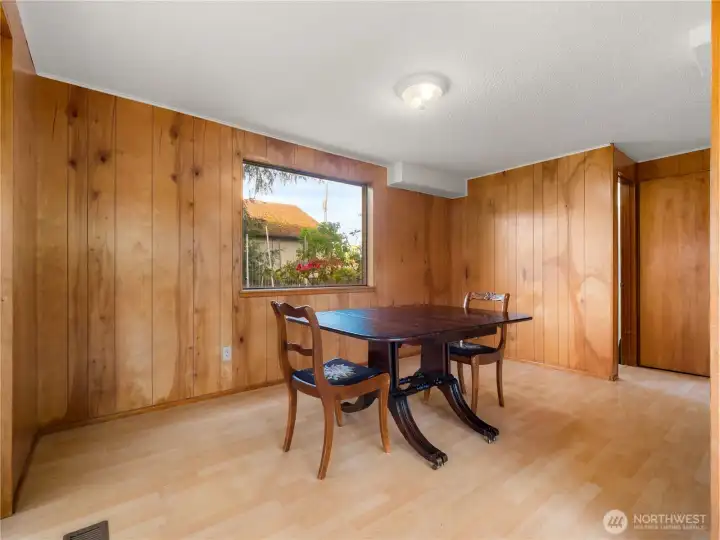 Another angle of the formal dining area highlights a bright window that brings in natural light and enhances the warm, inviting atmosphere.