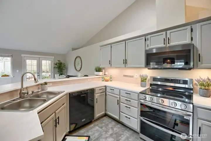 Updated Kitchen features grey tiled flooring, lots of cabinets and counter space, large pantry, double bay stainless sink with telescoping faucet, LG glass cooktop, double oven, Samsung microwave, Maytag dishwasher, Kenmore elite side by side refrigerator with pullout freezer & eating bar that's extra high & deep