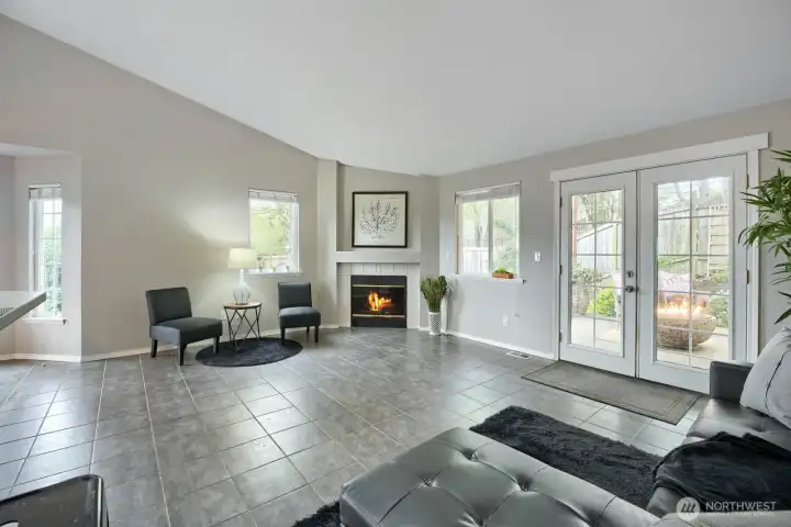 Gas fireplace with tiled surround and built-in hearth with recessed artwork nook; French doors to back yard