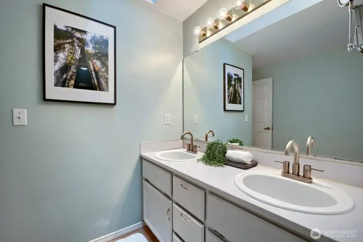 Primary bed's bathroom with skylight, double sinks, updated faucets, extensive mirror- including accordion wall mirror