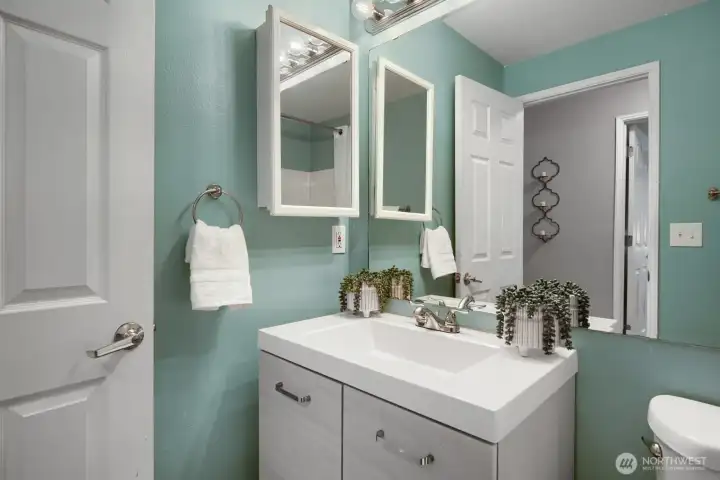 Main bathroom has been updated with 6 panel door, tile floors, contemporary vanity, extensive mirror, mirrored medicine cabinet, new toilet & one piece bathtub surround