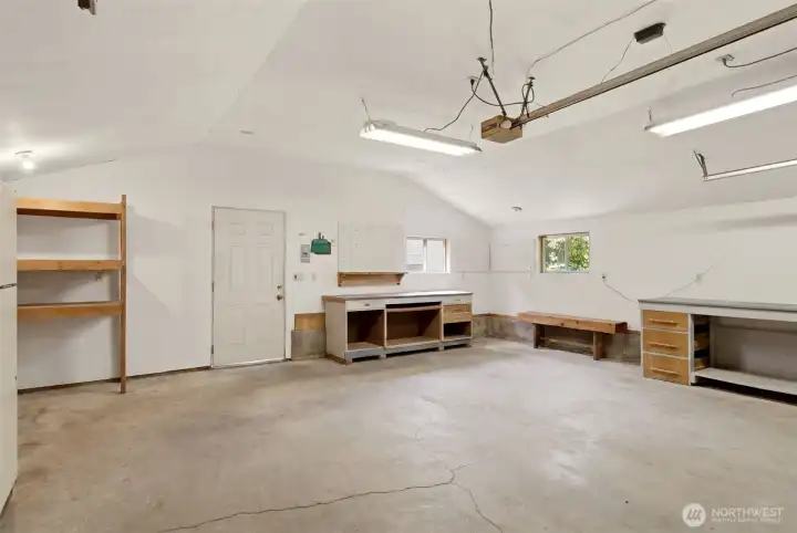 Large, detached two care garage features several shelving and work bench spaces