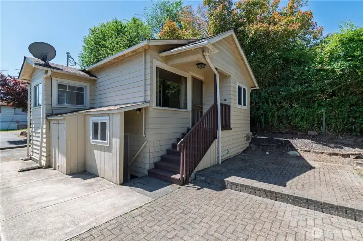 Backside of house w/patio. Stairs going up lead to kitchen and stairs going down is basement access. Basement has access via the interior as well. Backside of house w/patio. Stairs going up lead to kitchen and stairs going down is basement access. Basement has access via the interior as well.