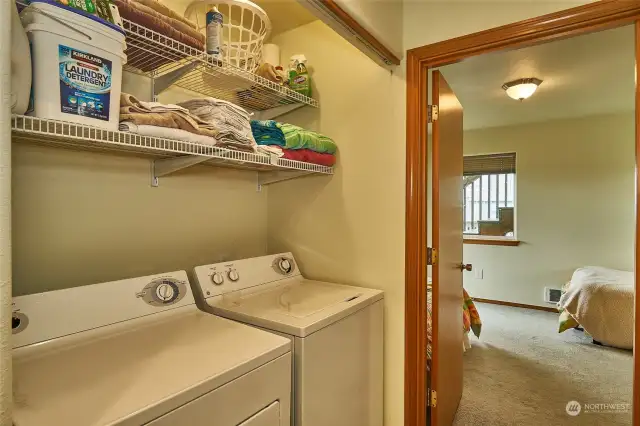 Washer and dryer set in hallway on 2nd floor, with shelving.