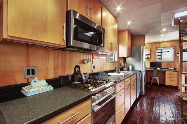 The kitchen has generous counter space, outlets, and cabinets.  The stove is hooked up to propane gas and the propane tank is located just to the right of the front door starboard side making it effortless to change the tank.