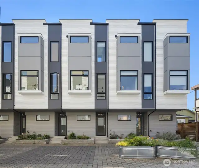 Front of unit G framed with windows allowing natural light to fill the interior. Quiet paver drive granting access to unit. Steps leading to front entrance of unit.