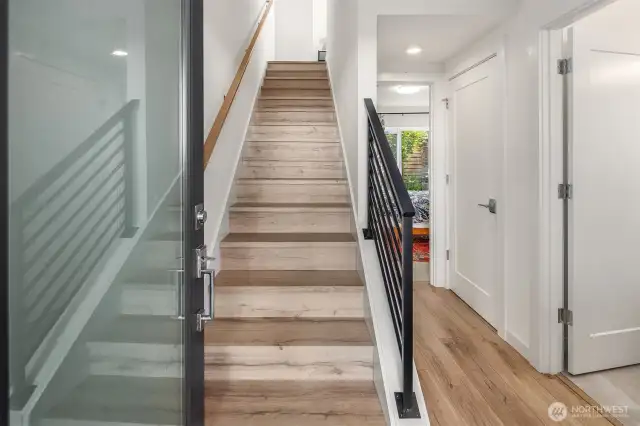 Entrance to unit opens to foyer with access to first floor bedroom, laundry, and bathroom as well as stairway leading to upper floors.