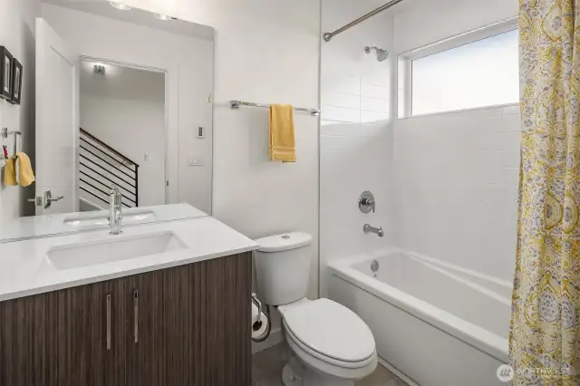 Full bathroom located on first floor equipped with ample storage space.
