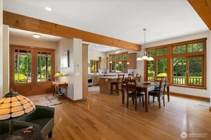 View back to entry, kitchen and dining space.  The European styled wood wrapped windows are plentiful give amazing views of private beautiful landscaped yard and grounds.