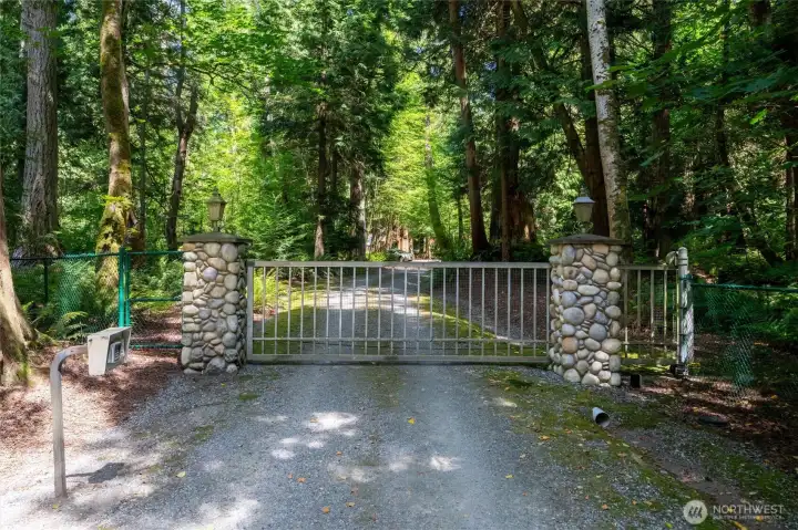 Gated entry at end of gravel drive .