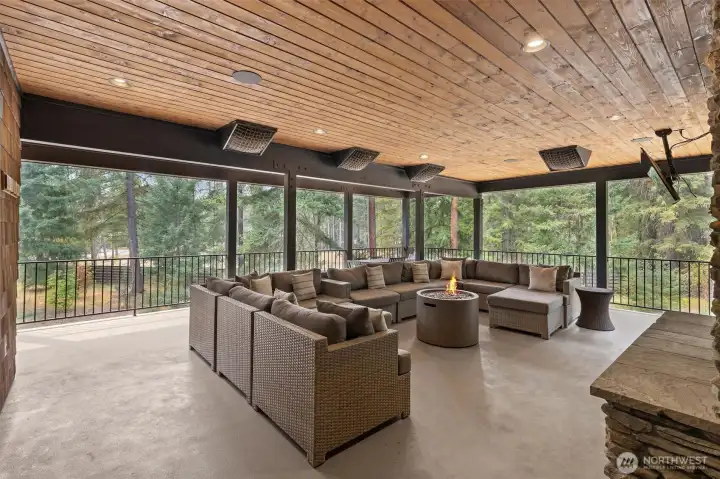 Covered deck with heaters, fireplace and TV.
