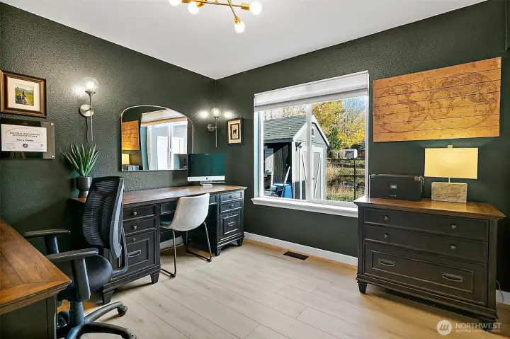 Main floor bedroom next to a full bath offers versatile space for guests, office, or additional living space.