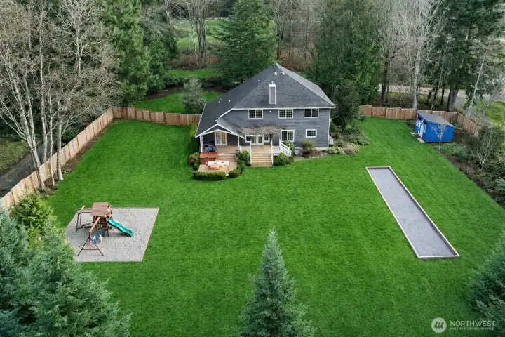Fully fenced backyard with Bocce Ball Court, Fire Pit, Shed and Play Structure