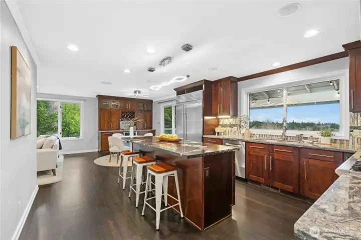 Chef’s kitchen is amazing and opens into an informal family and dining room with access to the covered deck.  Large island, SubZero Refrigerator, Wolf Gas Cooktop & Stove, designer lighting, Instant Hot Faucet, Beverage Center and a Window to watch the sun set as you finish the evening dishes.