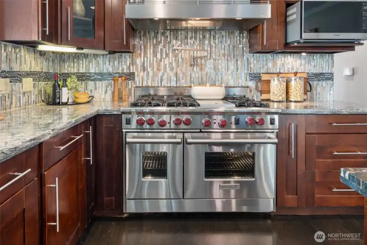 Wolf 6 burner Gas Cooktop + skillet, PLUS Pot Filler over cooktop and double oven!!  Built in spice rack to the right and an industrial strength hood.