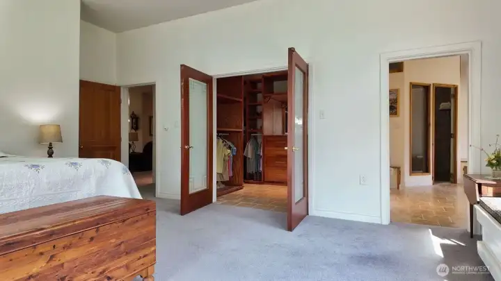 Primary bedroom view looking toward entrance, walk in closet and en-suite bathroom.