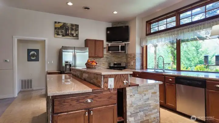 Kitchen island w/lots of storage room and shelves. Entrance to the laundry room behind island & left of refrigerator.