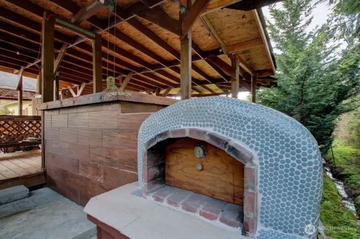 Out door pizza oven and remote controlled smoker on the left.