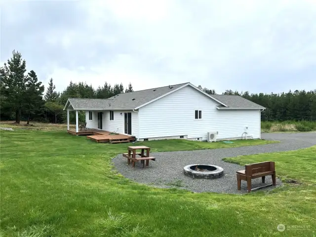 North side of property, facing south fire pit, picnic table, and bench on compressed gravel.