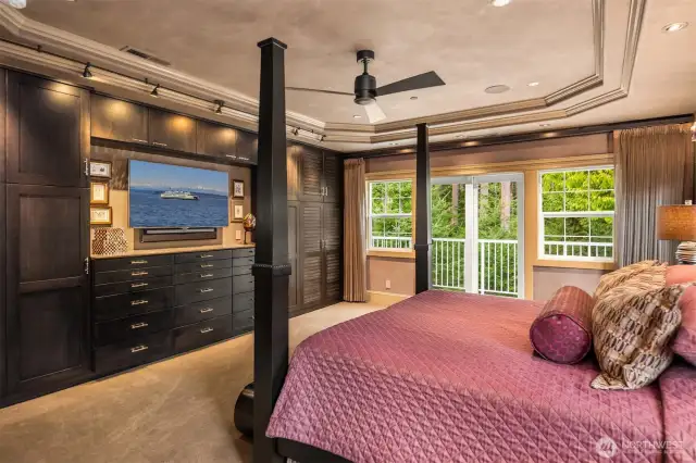 Primary with a wall of custom cabinets and designer lighting.