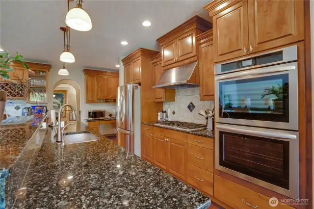 You will enjoy granite slab countertops, stainless steel appliances, a gas cooktop, full tile backsplash, and abundant storage throughout this chef's kitchen.