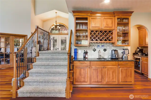 Glass-fronted cabinetry enhances the designer elements of this entertainer's dream kitchen. Observe the second sink, wine rack, and added storage.