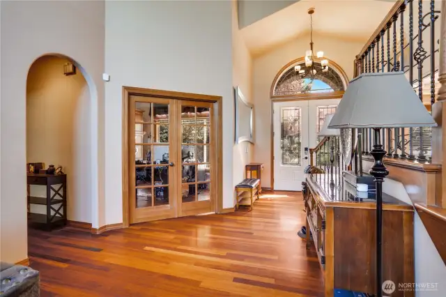 French doors welcome you into the spacious office which offers serene morning views. Note the continued arched details on the way to the main floor primary bedroom.