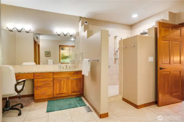 The primary bathroom features tile flooring, double vanities, and a spacious walk-in shower.
