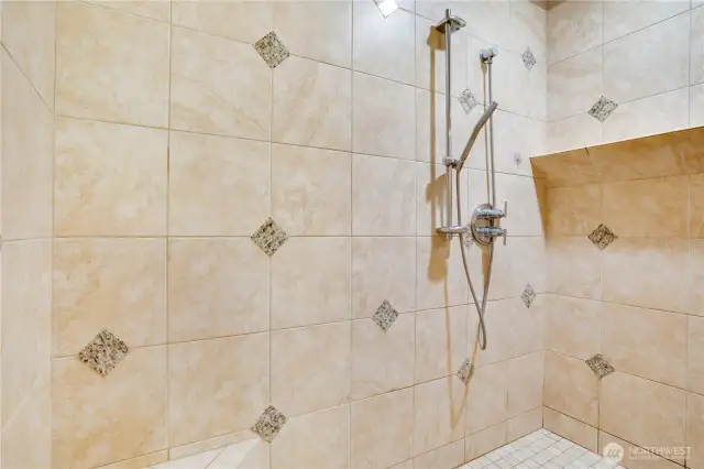 The handheld shower wand and rain shower head complement each other.