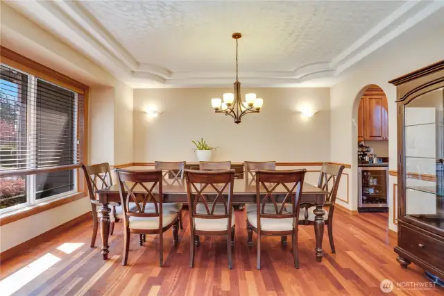 The spacious dining room is ideal for holiday gatherings, featuring a double tray ceiling with intricate details, along with chair rail and wainscoting for an elegant touch.