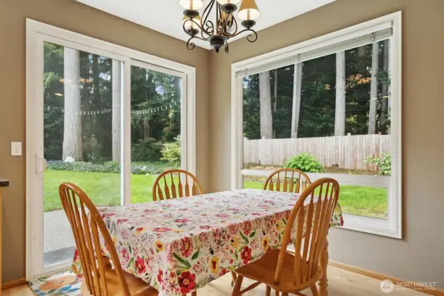 Informal kitchen eating space with windows surround and glass slider to rear yard and patio.