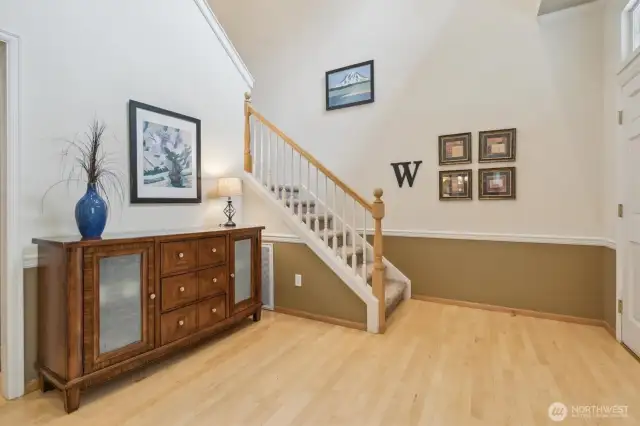 The entry way boasts soaring ceilings and genuine hardwood floors.