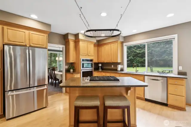 Featuring stainless steel appliances and island gas range. The hanging pot rack awaits for your culinary tool storage.